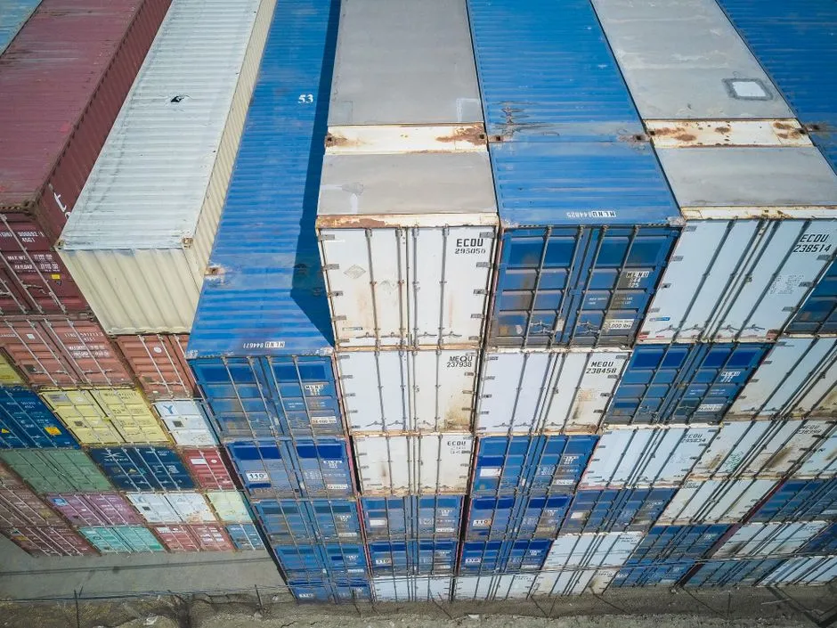 Aerial view of stacked multicoloured shipping containers at a container yard